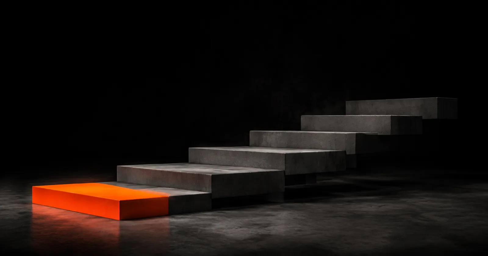 A concrete staircase with the bottom step lit in orange